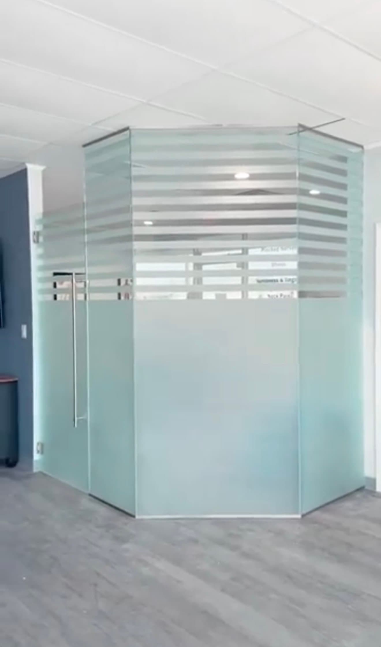 Modern hexagonal frosted glass office pod with horizontal stripes and a sleek glass door.
